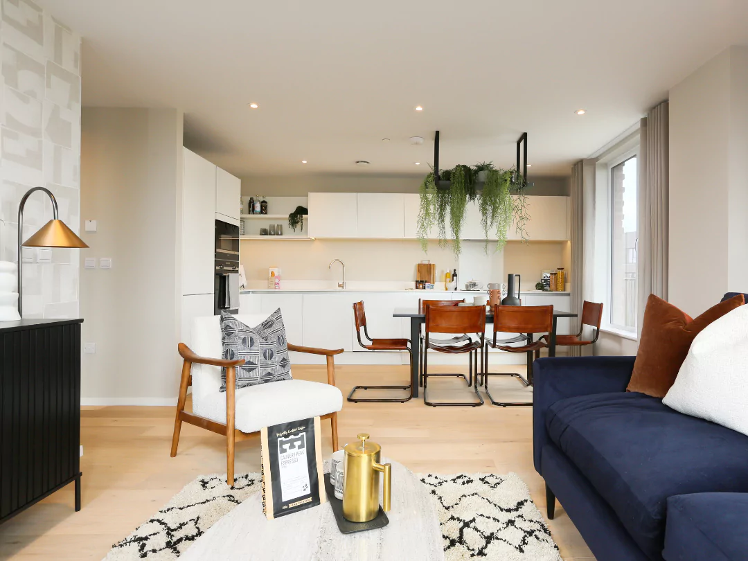 Open-plan kitchen diner with stylish white work tops and a stylish living space.