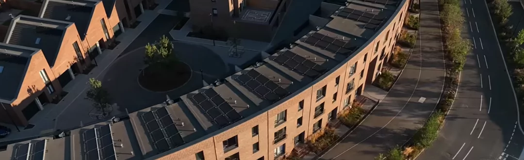 Aerial view of sustainable, red brick townhouses at Brabazon, showcasing  complete with PV solar panels on every home, tree-lined streets and wide cycle and walkways. 