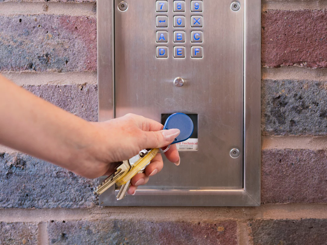 A close up of the apartment door fob featuring a ladies manicured hand.