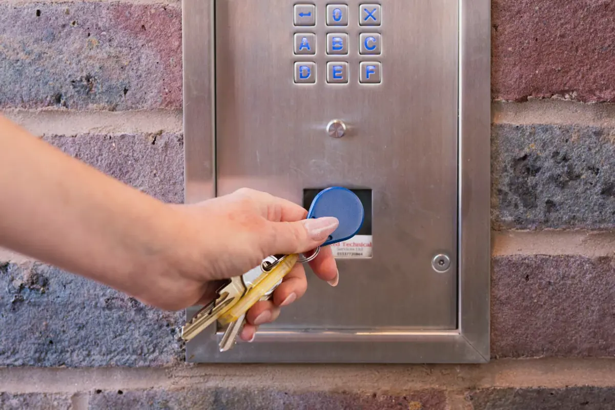 A close up of the apartment door fob featuring a ladies manicured hand.