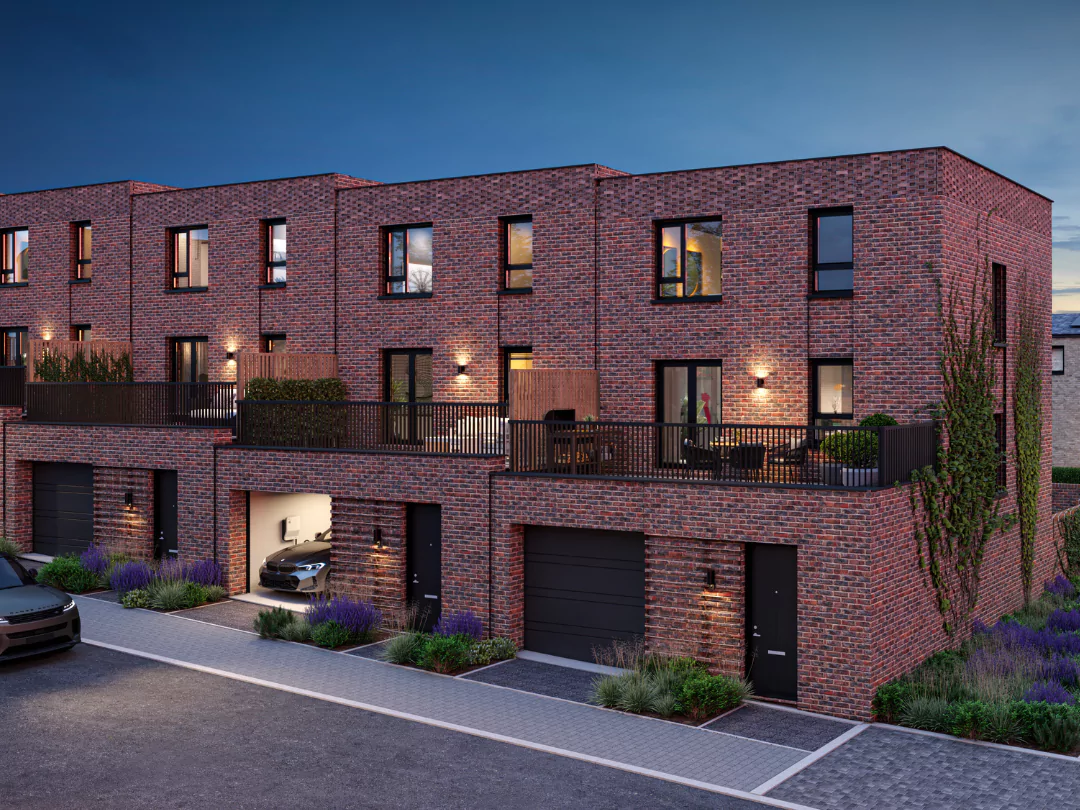 A row of terraced Buckingham homes with carport garages and balcony gardens on a landscaped street at Brabazon.