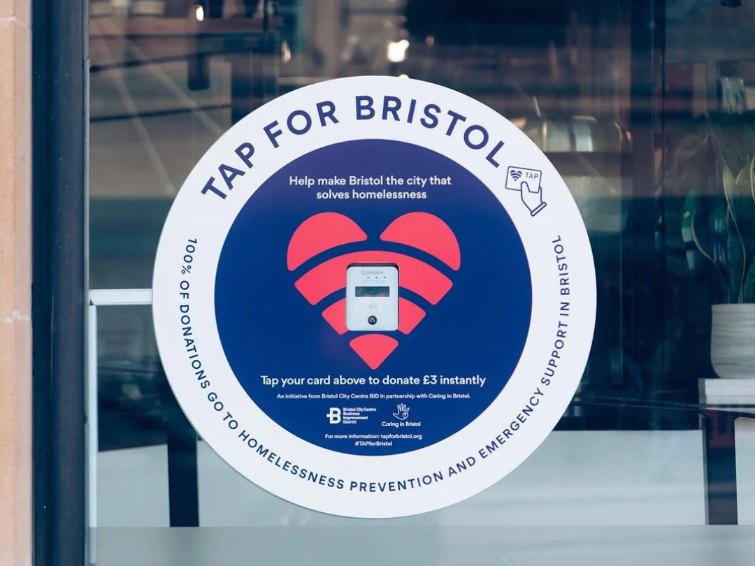 Tap for Bristol sign on business window, offering contactless donation point via card payment in Bristol.