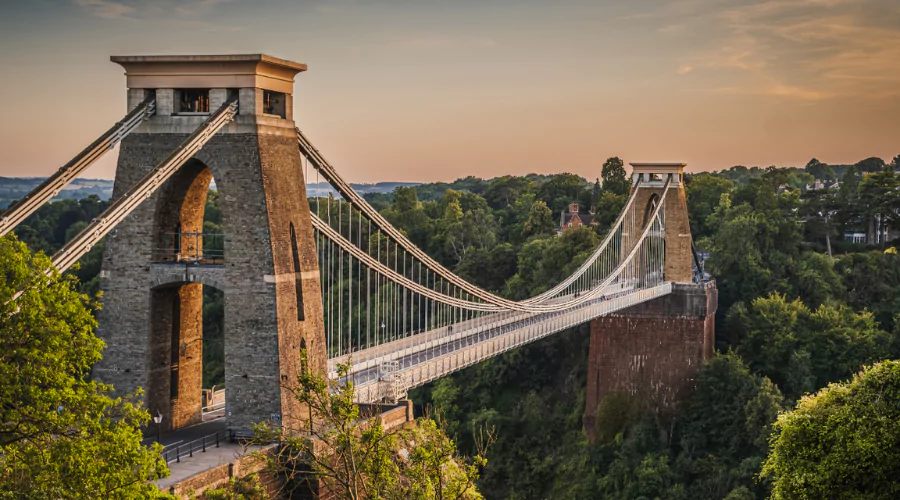 Bristol's famous Clifton Suspension bridge: a Grade I listed bridge over a green valley at sunset.