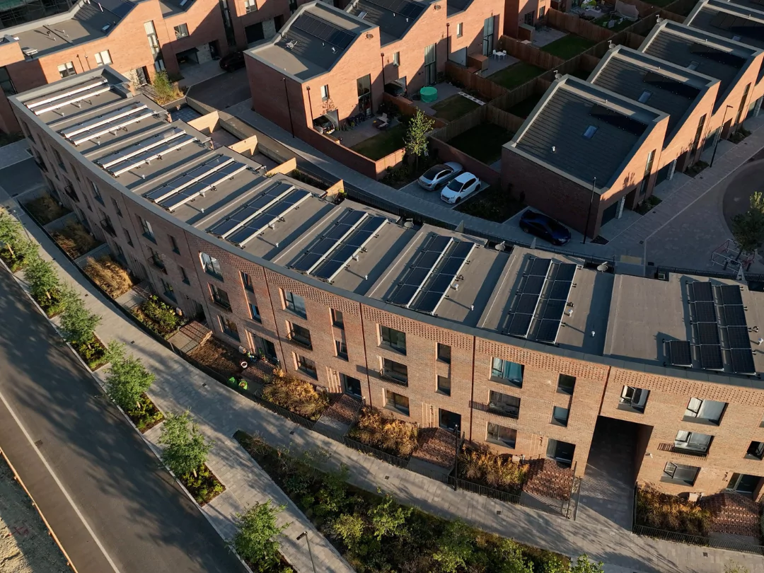 Ariel view of Fairlawn Avenue at The Hangar District, showcasing terraced housing along a crescent road with solar panels on each roof. 