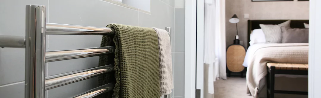 Chrome towel rail with towels hanging in a master en-suite bathroom.