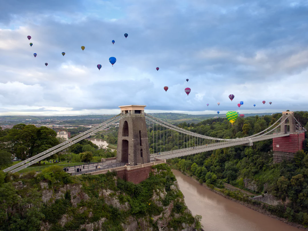 Bristol Suspension Bridge with a drift of colourful hot air balloons in the sky. 